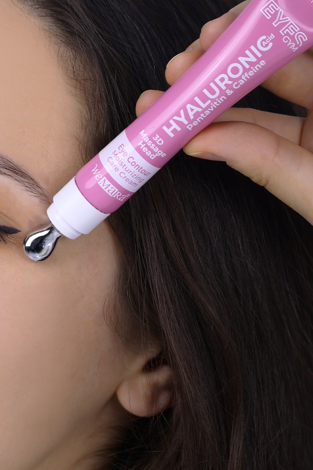 Person applying a pink eye serum to their eyelid with a dropper.
